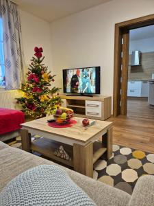 a living room with a christmas tree and a coffee table at Apartmány Karina in Janske Lazne