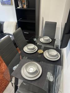 a dining room table with plates on top of it at Cozy 2 Bed Flat in Town Centre in Royal Tunbridge Wells