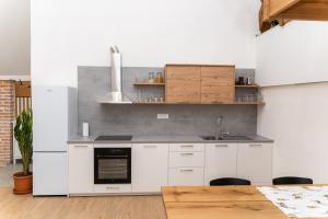 a kitchen with white cabinets and a sink at Timeless Barn in Ljubljana
