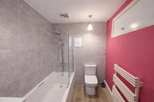 a bathroom with a tub and a toilet and a shower at Dog Friendly Lakeland Apartment - Private Parking - Central Location in Cockermouth +12 photos