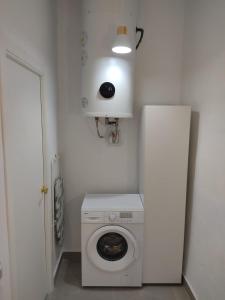 a washer and dryer in a white room with a door at La corrala de la calle Sol in Jerez de la Frontera
