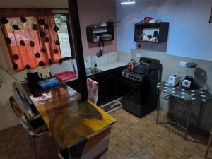 a small kitchen with a table and a stove at La Martha in Sarapiquí +5 photos