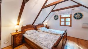 a bedroom with two beds in a attic at Moslavačka Priča Holiday Homes in Mala Ludina