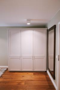 a closet with white cabinets and a mirror at Sünn un See - Hortensienblick in Ahrenshoop