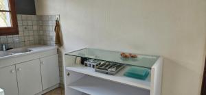 a bathroom with a sink and a glass shelf at Studio plainpied in Saint-Doulchard