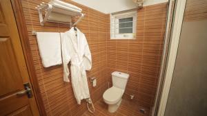 a bathroom with a toilet and towels on a wall at Four Squares by WIH in Karachi +187 photos