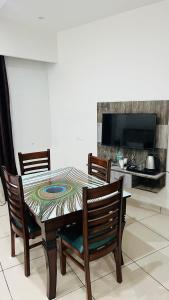 a dining room with a table and chairs and a tv at Divine Hotel in Zirakpur