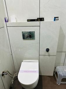 a bathroom with a toilet with a sign on it at Divine Hotel in Zirakpur +6 photos
