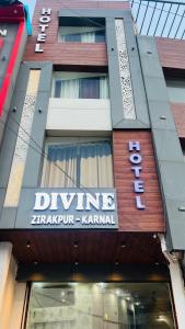 a building with a sign for a drive istg at Divine Hotel in Zirakpur