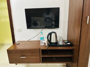 a tv sitting on top of a wooden entertainment center at Divine Hotel in Zirakpur