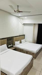 two twin beds in a room with a ceiling at Divine Hotel in Zirakpur