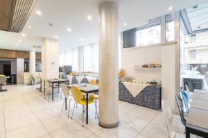 a dining room with tables and chairs and windows at Wyndham Garden Conegliano in Conegliano