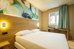 a bedroom with a large white bed in a room at Wyndham Garden Conegliano in Conegliano +17 photos