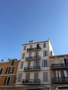 een hoog wit gebouw met balkons in een straat bij A 2 pas de la croisette in Cannes