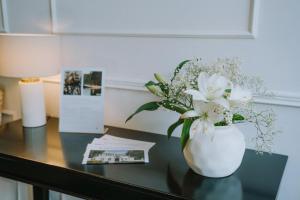 a vase with white flowers on a table at KAROLINGERHOF - Mosel in Kröv