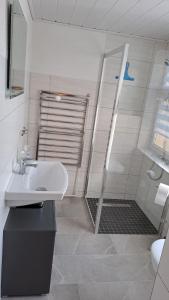 a white bathroom with a sink and a shower at Ferìenwohnung Mende 1 in Lübbenau +4 photos