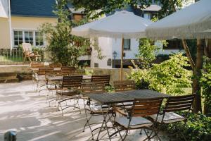 a row of tables and chairs with an umbrella at KAROLINGERHOF - Mosel in Kröv