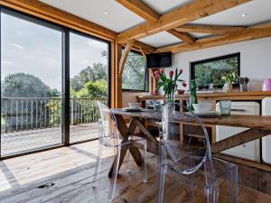 ein Esszimmer mit Tisch und Stühlen und einem Balkon in der Unterkunft Bydown Lodge - Swimbridge Devon in Swimbridge + 16 Fotos