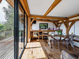 ein Zimmer mit einer Terrasse mit Tisch und Stühlen in der Unterkunft Bydown Lodge - Swimbridge Devon in Swimbridge
