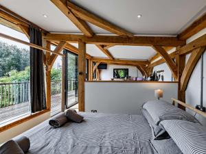 ein Schlafzimmer mit einem Bett und einem großen Fenster in der Unterkunft Bydown Lodge - Swimbridge Devon in Swimbridge