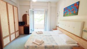 a bedroom with a bed with two towels on it at Hotel Milord in Cesenatico
