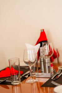 a wooden table with glasses and napkins on it at Explora Lodge in Arusha