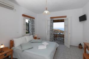 ein Schlafzimmer mit Bett und Meerblick in der Unterkunft Spitha Sifnos in Artemonas