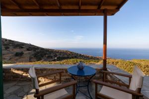 eine Terrasse mit zwei Stühlen und einem Tisch mit Aussicht in der Unterkunft Spitha Sifnos in Artemonas