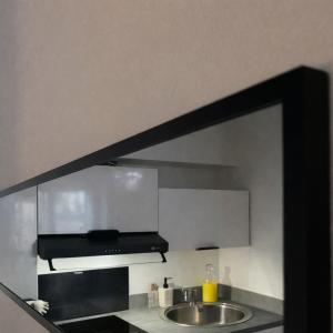 a mirror above a sink in a kitchen at L'Âtre Angevin - cheminée d'époque - Doutre in Angers +1 photo