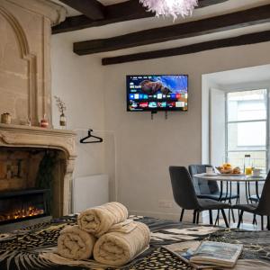 a room with a fireplace and a tv on the wall at L'Âtre Angevin - cheminée d'époque - Doutre in Angers