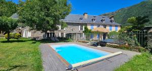 a large swimming pool in front of a house at Les Échappées Belles - Gîtes et chambres d'hôtes 4 étoiles in Antignac