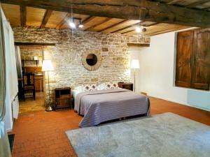 a bedroom with a bed and a stone wall at La Longère du Sallay in Saincaize-Meauce