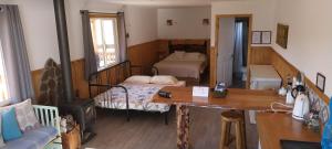 a living room with a room with two beds and a table at Cabaña Lefuco, Curacautin in Manzanar