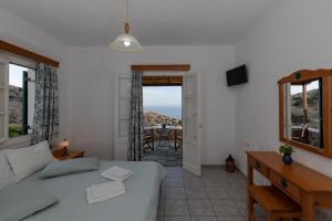 ein Wohnzimmer mit einem Bett, einem Tisch und einem Fenster in der Unterkunft Spitha Sifnos in Artemonas