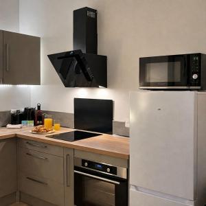 a kitchen with a refrigerator and a microwave at Instant Angers Hyper Centre in Angers