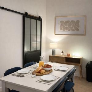 a table with a bowl of bread and a bowl of fruit at Instant Angers Hyper Centre in Angers +4 photos