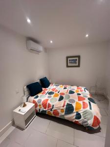a bedroom with a bed with a colorful comforter at Le magasin in Conca