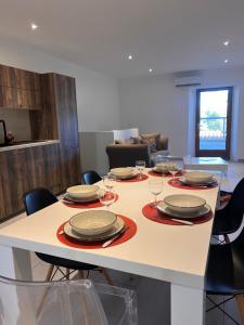 a table with plates and wine glasses on it at Le magasin in Conca