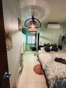 a bedroom with two beds and a chandelier at MILD ISLAND STAY ROOm in Phi Phi Islands +2 photos