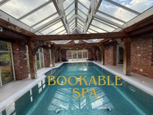 a swimming pool in a conservatory with a glass roof at North Lodge at Pudleston Court in Hatfield