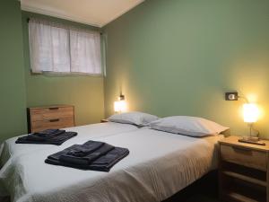 a bedroom with a bed with two towels on it at Alexander Lodge in Isolaccia