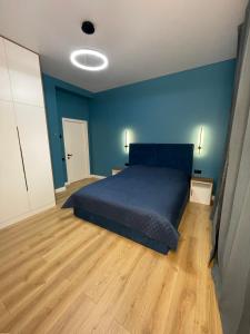 a bedroom with a bed with blue walls and wooden floors at House by River in Yerevan
