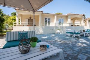 a patio with a table and chairs in front of a house at Alexia Studios in Kolios