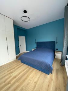 a blue bedroom with a bed and a wooden floor at House by River in Yerevan +35 photos
