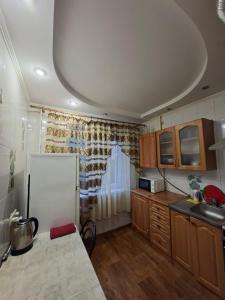 a kitchen with a white refrigerator and wooden cabinets at Терновской район in Kryvyi Rih