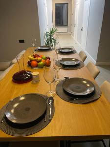 a wooden table with plates and wine glasses on it at House by River in Yerevan