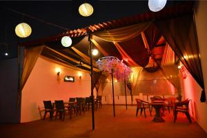 a dining room with tables and chairs and lights at Hotel Rainbow in Yamunānagar