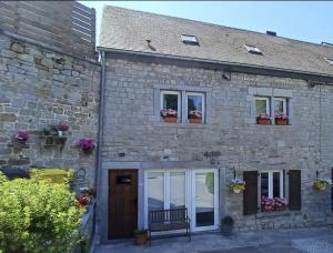 a stone house with two windows and a bench at Le chant des sirènes in Mettet