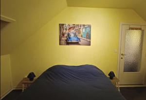 a bedroom with a bed and a picture of a car on the wall at Le chant des sirènes in Mettet +1 photo