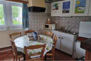 a kitchen with a table with chairs and a microwave at Le chant des sirènes in Mettet